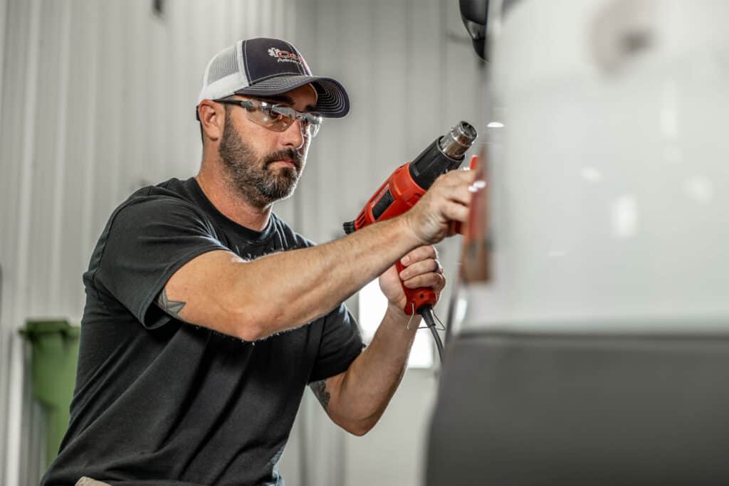 Osage ambulance employee working on the decals of an ambulance