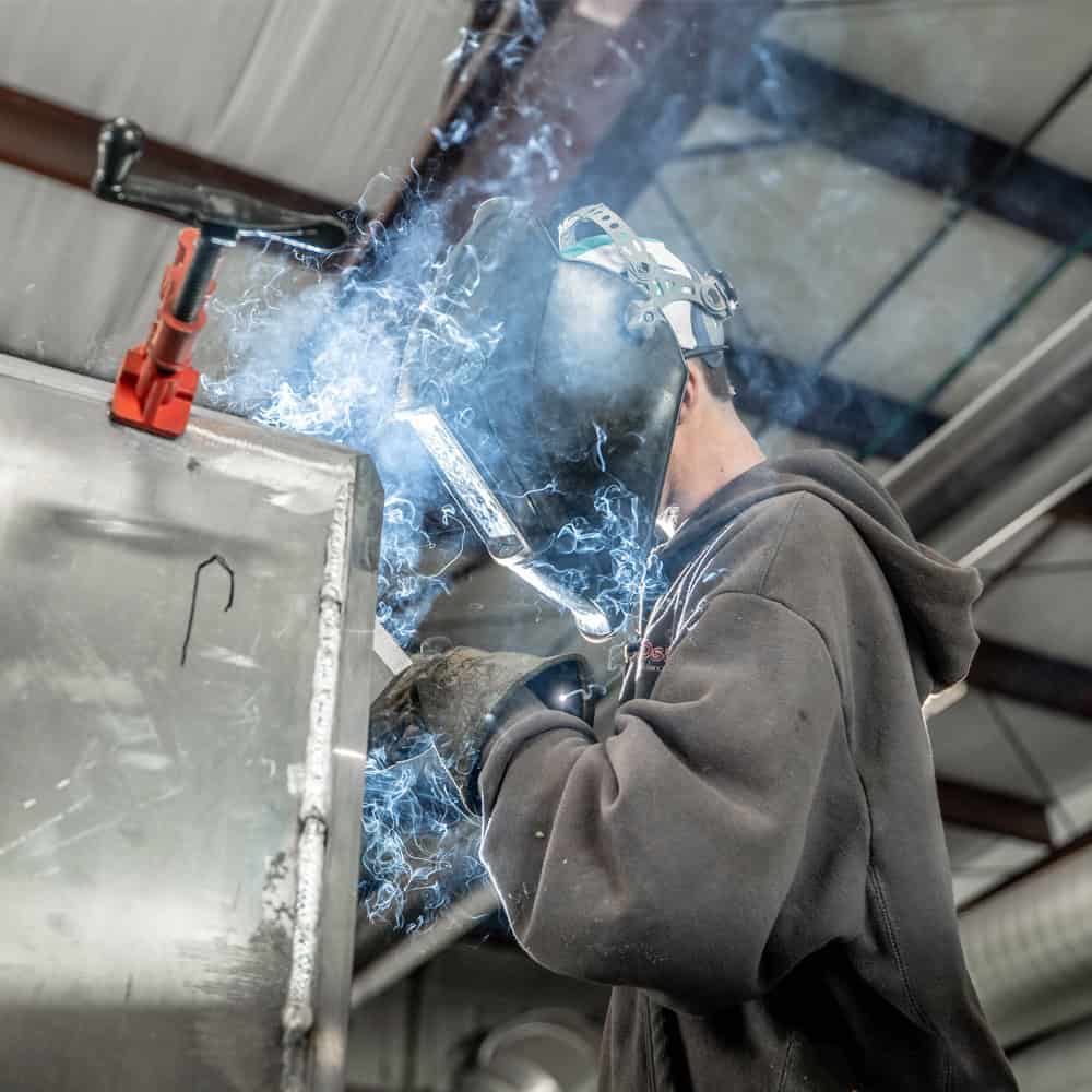 Osage Ambulance employee welding the top of a box